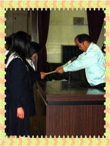 先生が生徒に賞状を渡している写真
