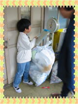 ゴミ袋を計量している男の写真