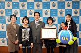 市長と表彰状を持った女の子、いちみんのぬいぐるみを持った女の子、その他3人で並んでいる写真