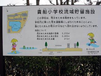 写真:貴船小学校流域貯留施設の説明看板。学校内に降った雨を運動場にしばらくにためることにより、急にたくさんの雨水が川などへ流れ出さないようにしています。