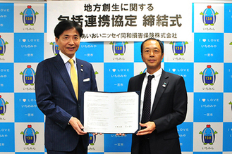 中野市長とあいおいニッセイ同和損害保険株式会社愛知北支店長が締結書を持って並んでいる写真