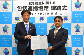 中野市長とKDDI株式会社中部総支社長が締結書を持って並んでいる写真
