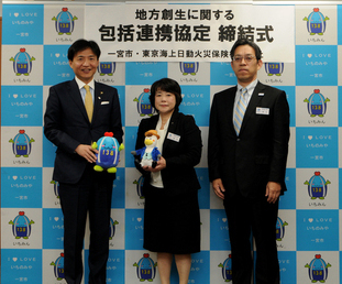 中野市長と東京海上日動火災保険株式会社の代表者2名がマスコットキャラクターのぬいぐるみを持って整列している写真
