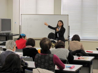 ホワイトボードに字を書きながら参加者に説明をする杉本美晴さんの写真