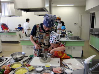 ピザ生地を作るお父さんと子どもの写真