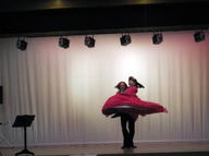 舞台上で男性ダンサーとともにオペラを踊る赤いドレスを着た大塚先生