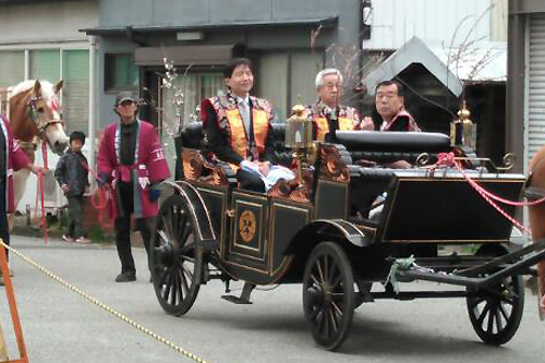 神幸行列で馬車に乗っている写真