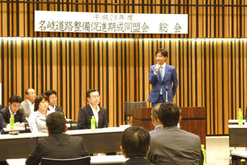 会議であいさつしている様子の写真