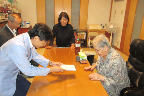 長寿の方を訪問し、お祝いしている様子の写真