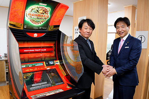 ゲーム機の前で握手する市長の写真