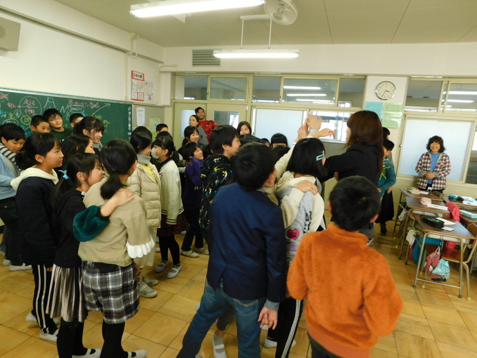 写真：ハイタッチをしている生徒たちと石野枝里子さん