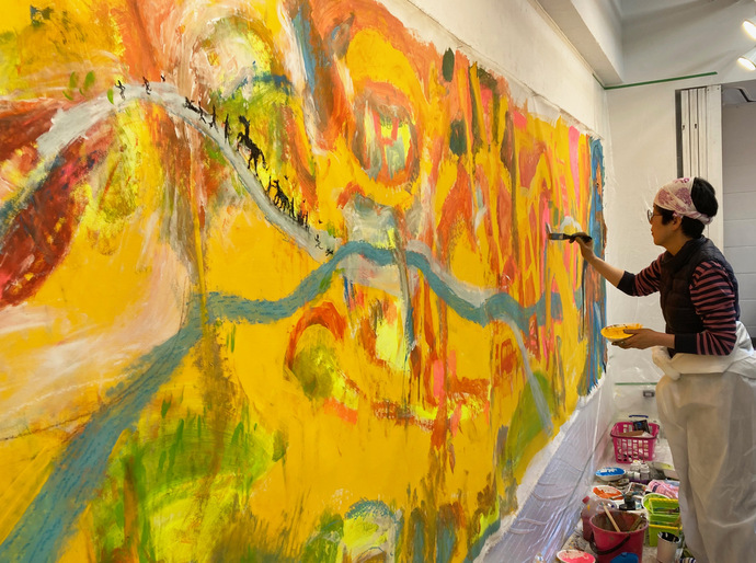 写真：作家の北村尚子さんが大きな絵を描いている