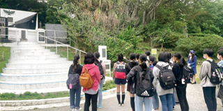 小桜の塔を中学生が見学している様子の写真