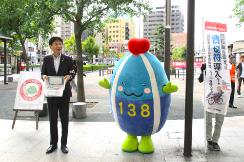 市長といちみんが、駅前広場で交通安全を呼びかけている様子の写真